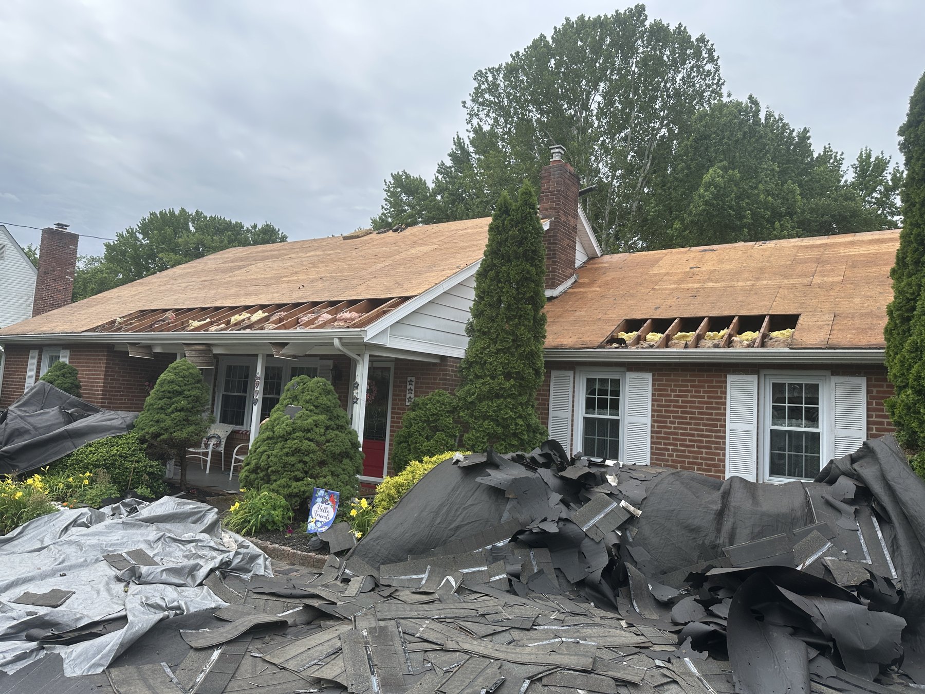 Roof tear-off in progress exposing decking on brick home in Mickleton NJ