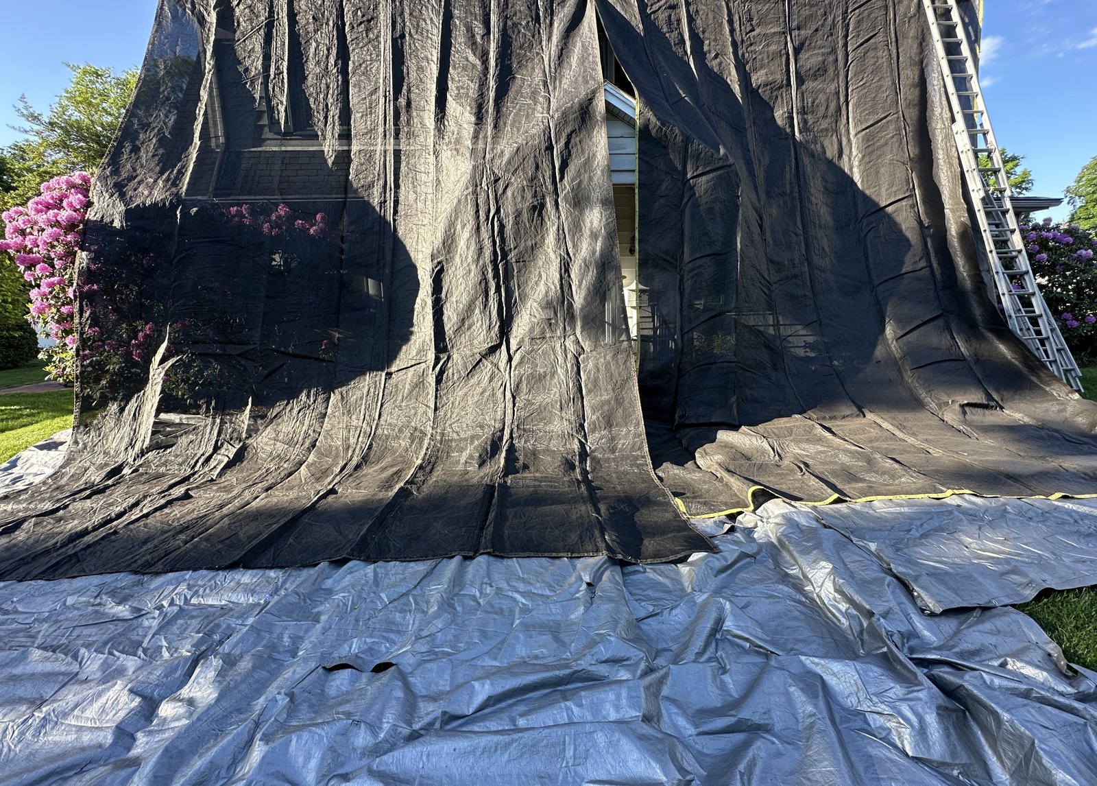Mesh and ground tarps protecting siding and landscaping during roof replacement in Pitman NJ